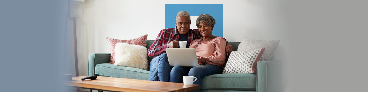 man en vrouw zitten met laptop op schoot op de bank